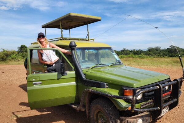 Happy female leans out of green pop-up roof vehicle