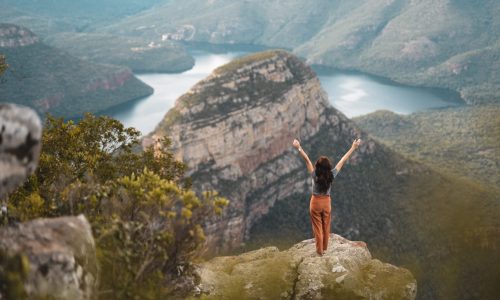 Female feeling free with open arms over Blyde River Canyon