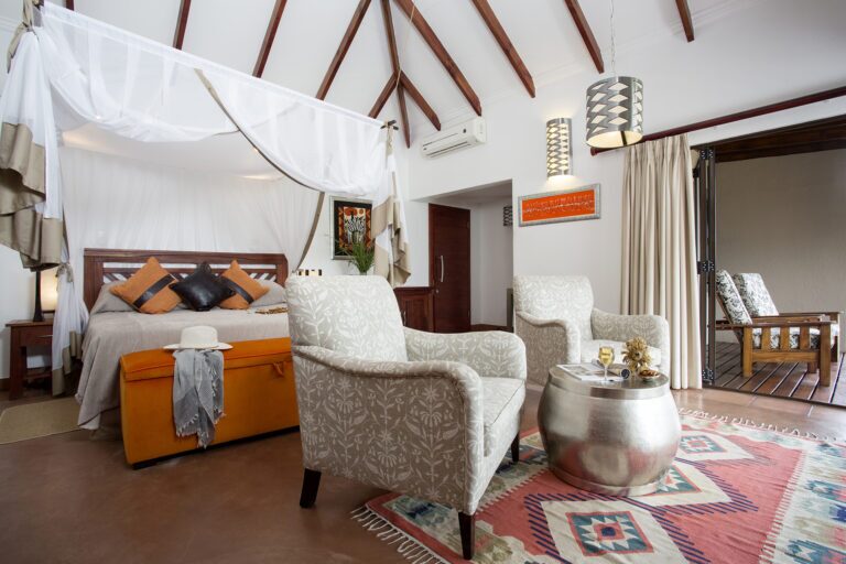 stylish bedroom with a bed, chairs and a table