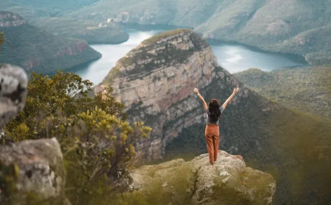 Female feeling free with open arms over Blyde River Canyon