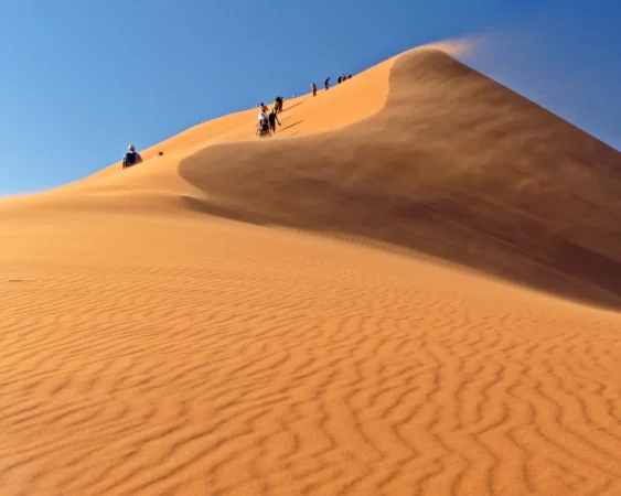 Group hike up Sossusvlei dune in windy conditions