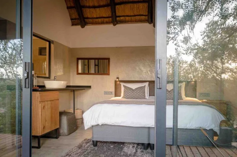 inside of a bedroom with a king bed and counter with basin on it