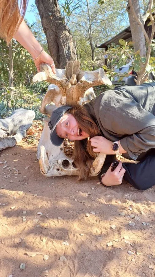 a woman posing with her head inside an animals skull