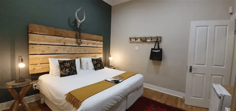 bedroom with double bed, wooden headboard and bedside tables with lamps