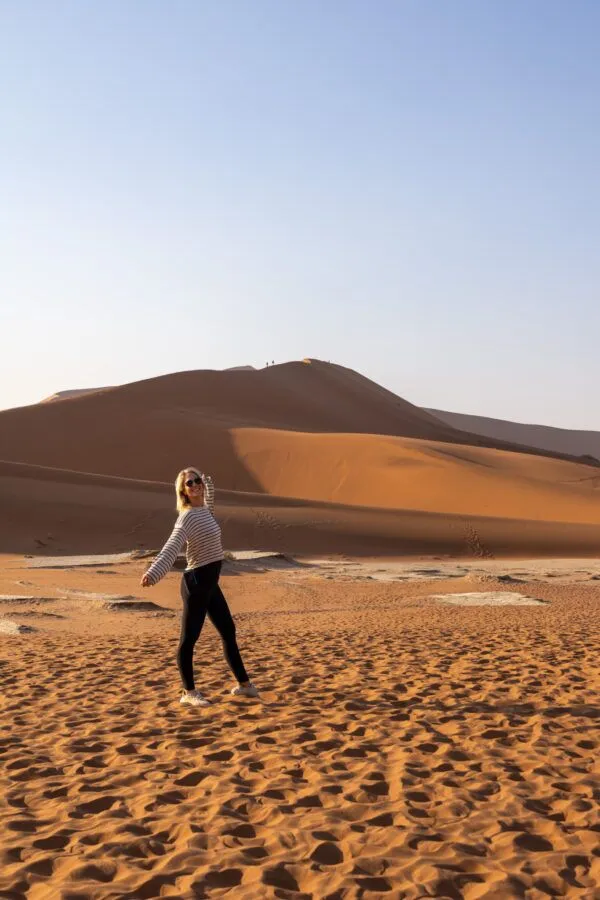 woman standing in the desert with dunes in the background