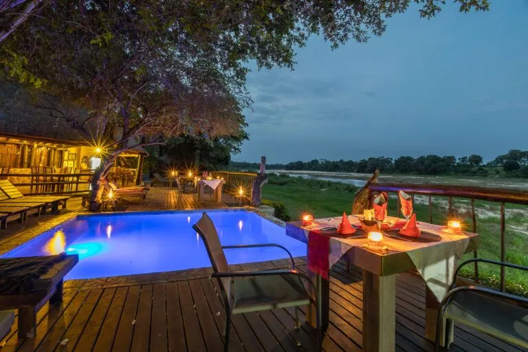 picture of a patio with a swimming pool and a table set for dinner