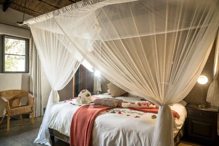 bedroom with flowers on the bed and mosquito net