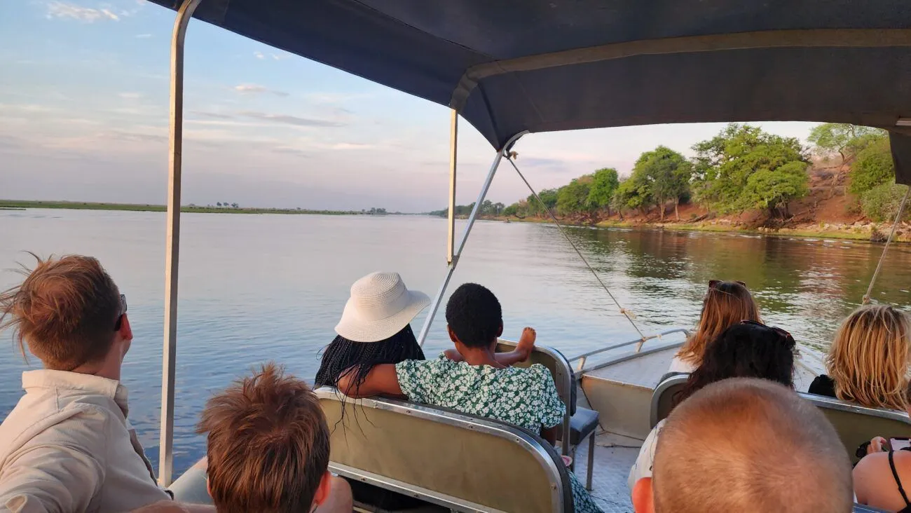 People on a boat cruise on Chobe River looking out for animals.