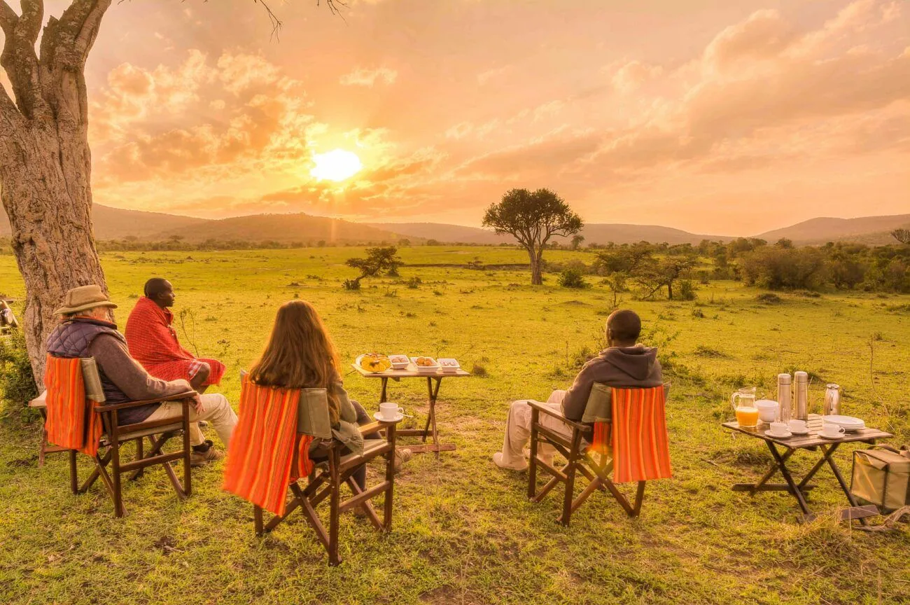 sitting on chairs on the grass enjoying the African sunset