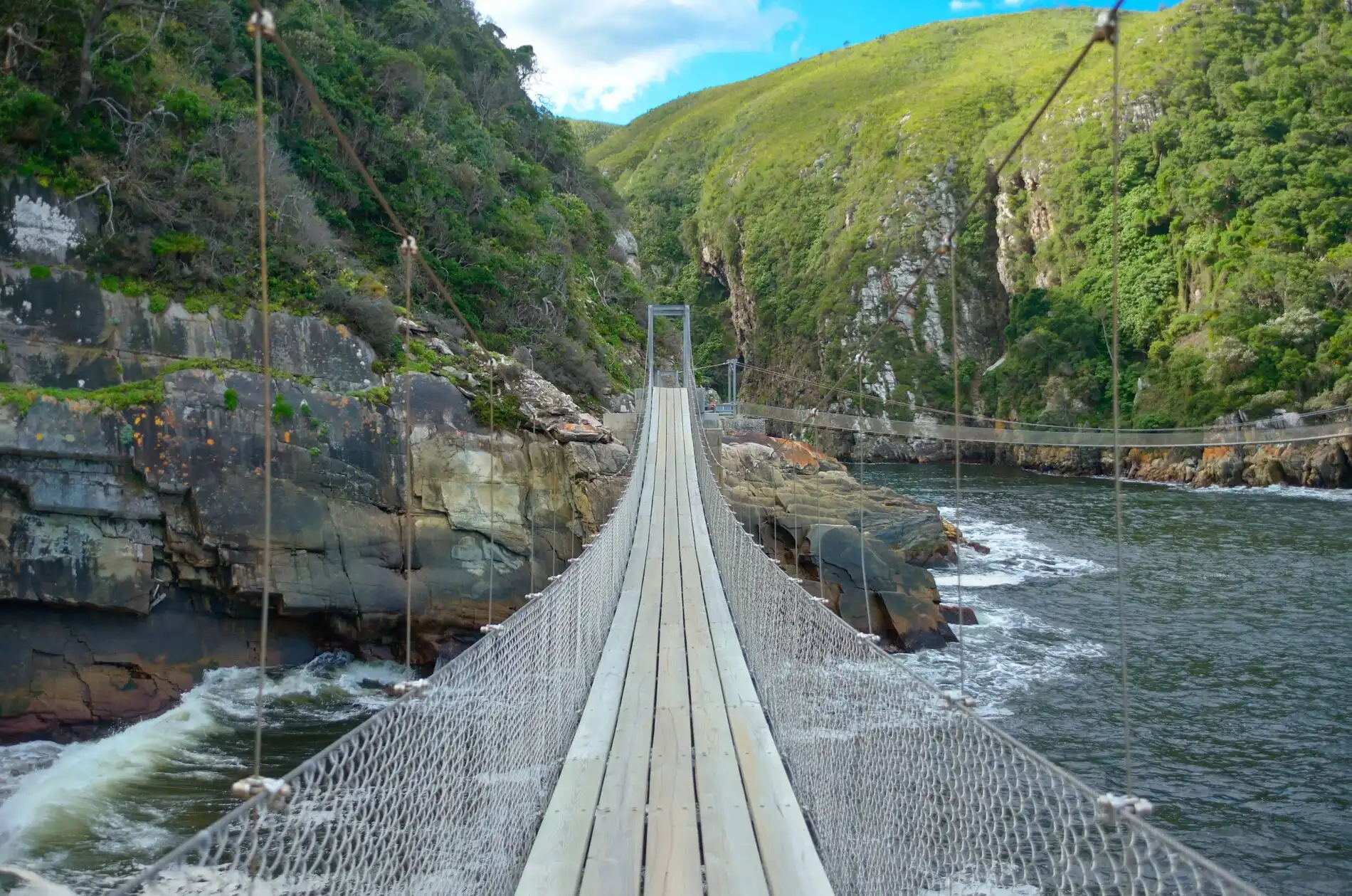 The picturesque Storms River bridge hanging between two ocean cliffs