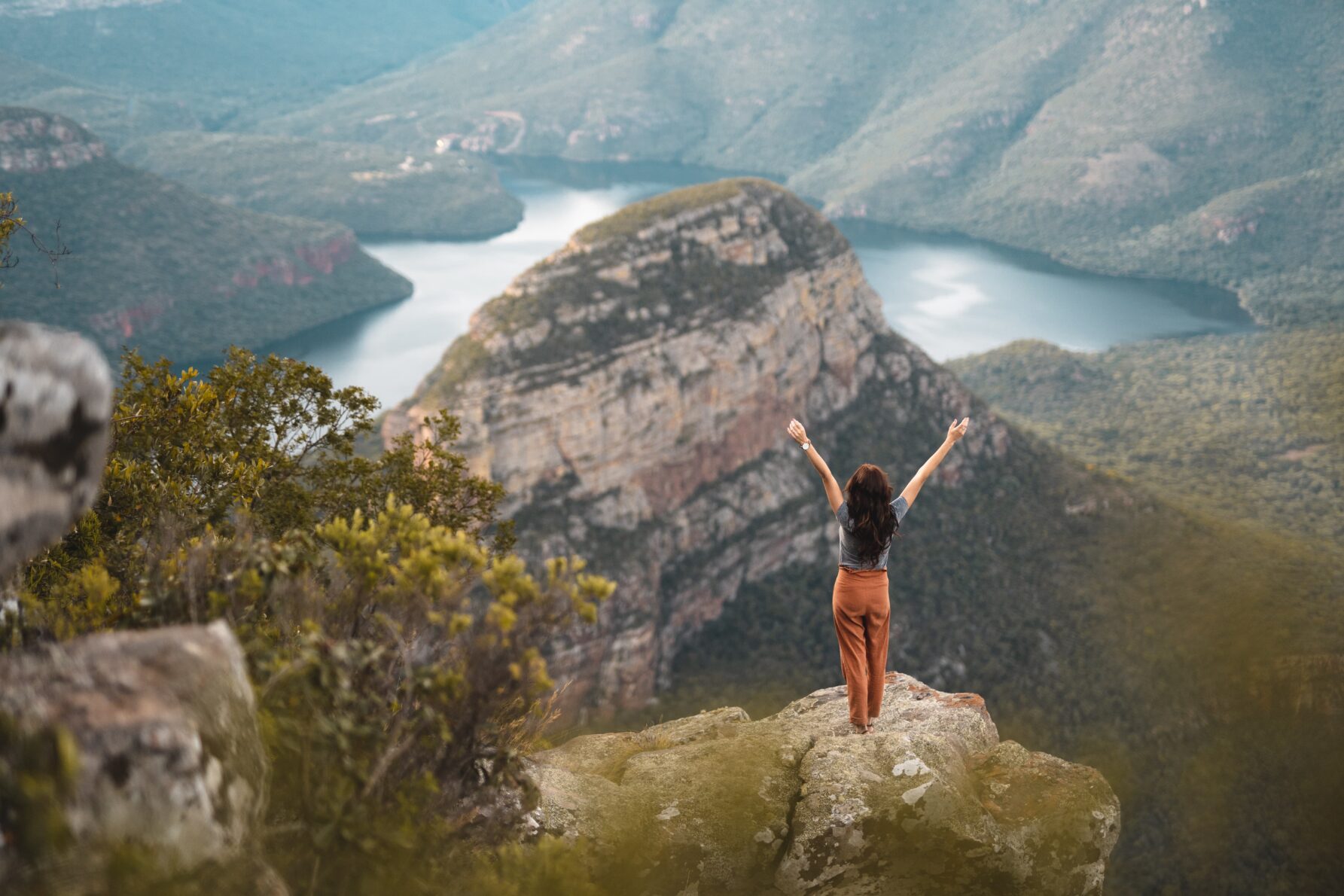 Female feeling free with open arms over Blyde River Canyon