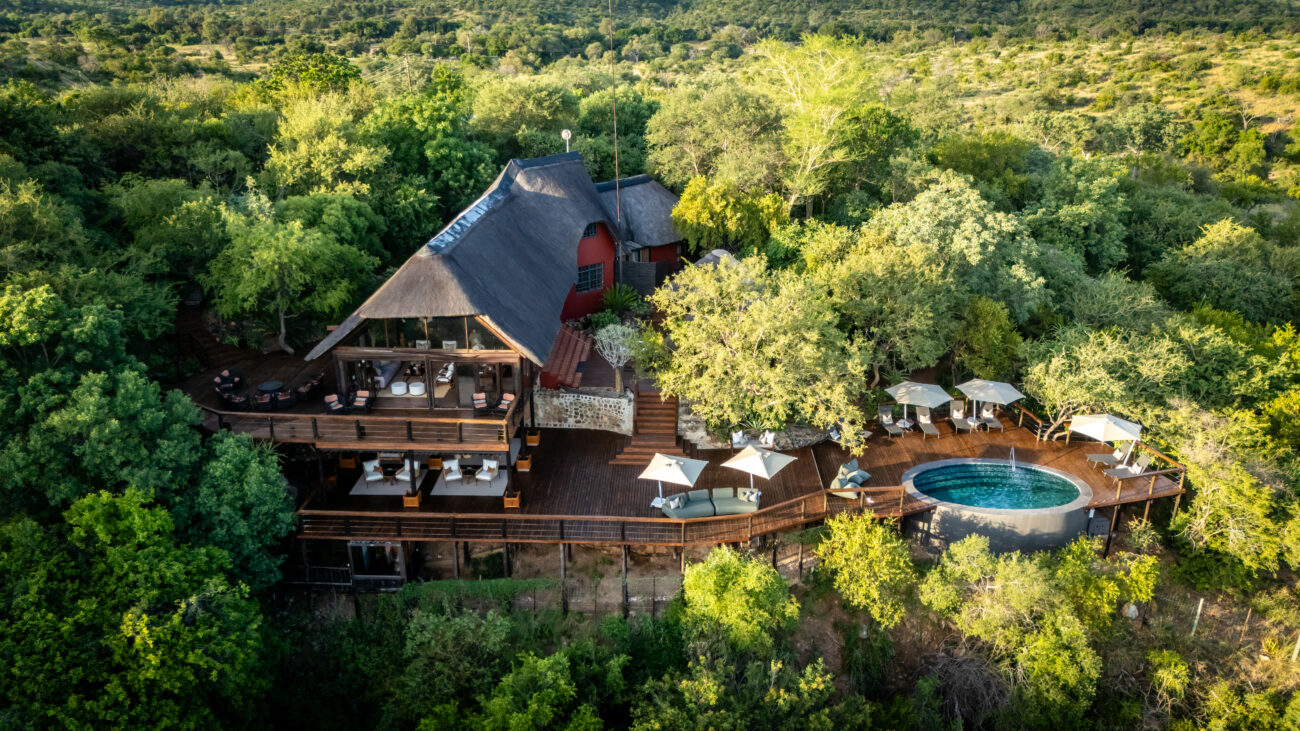 stunning view of lodge wit swimming pool and deck chairs