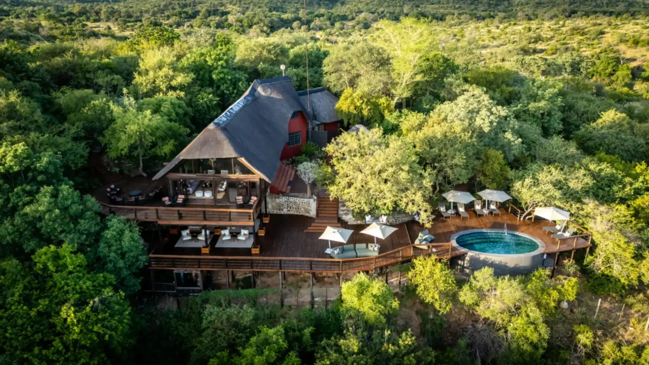 stunning view of lodge wit swimming pool and deck chairs