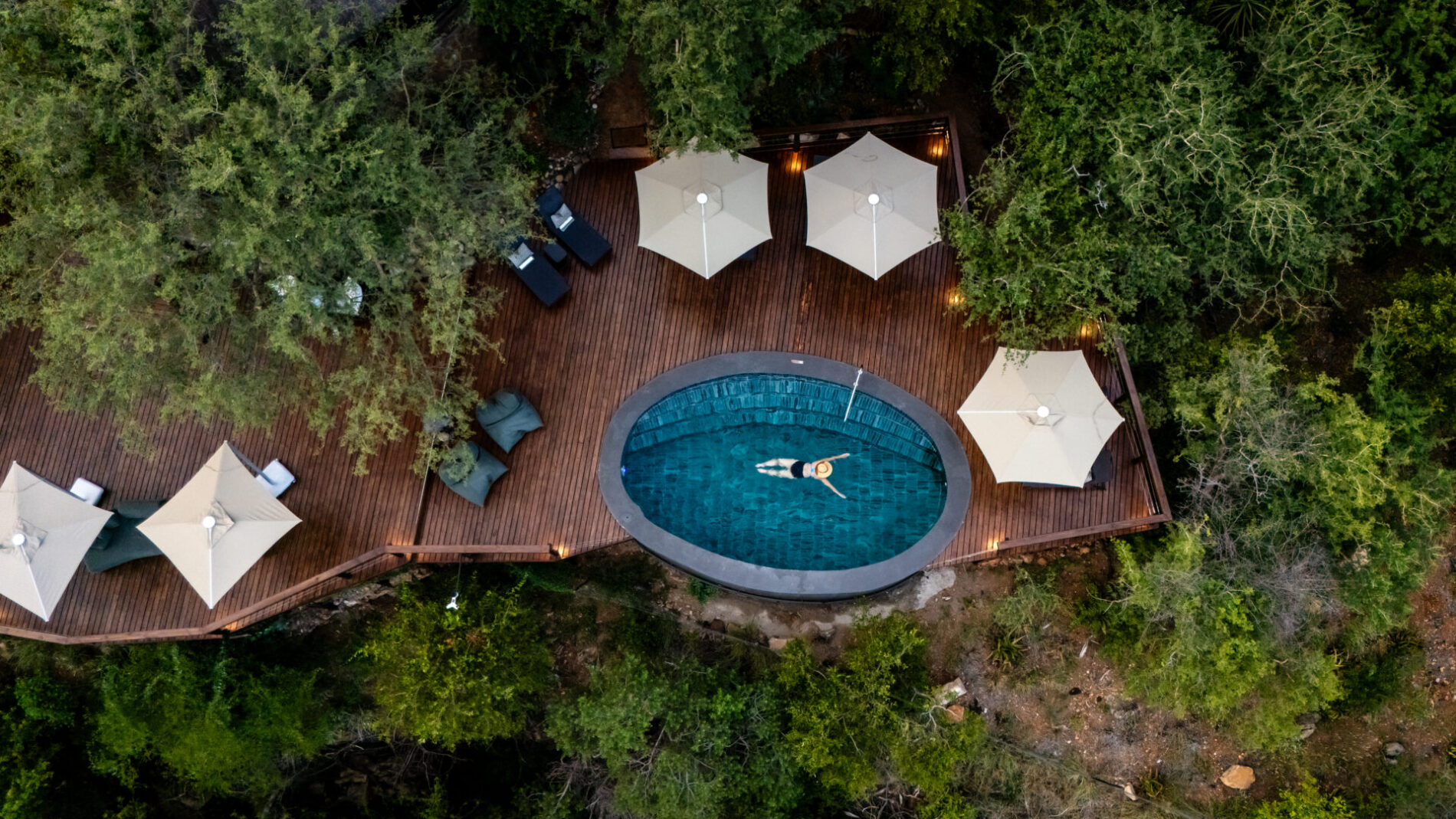aerial photo of person in swimming pool on deck