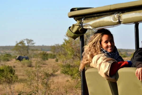 Smiling woman looks back at camera while on a game drive.