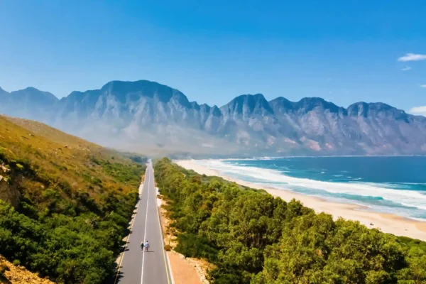 Couple walking on the road, drone aerial view, Kogelbay Beach with rugged coastline, Western Cape, South Africa