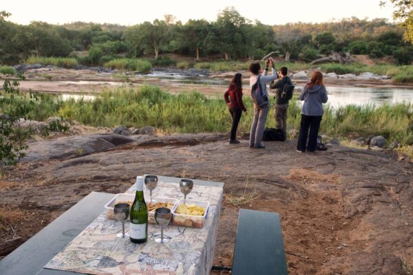 Bush drinks over riverbed with safari guests taking pictures