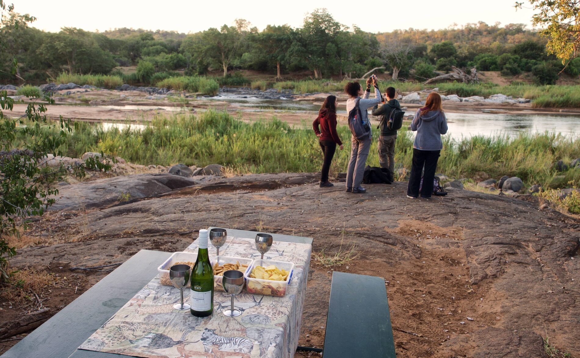 Bush drinks over riverbed with safari guests taking pictures