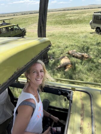 woman sticking her head out the top of a safari vehicle