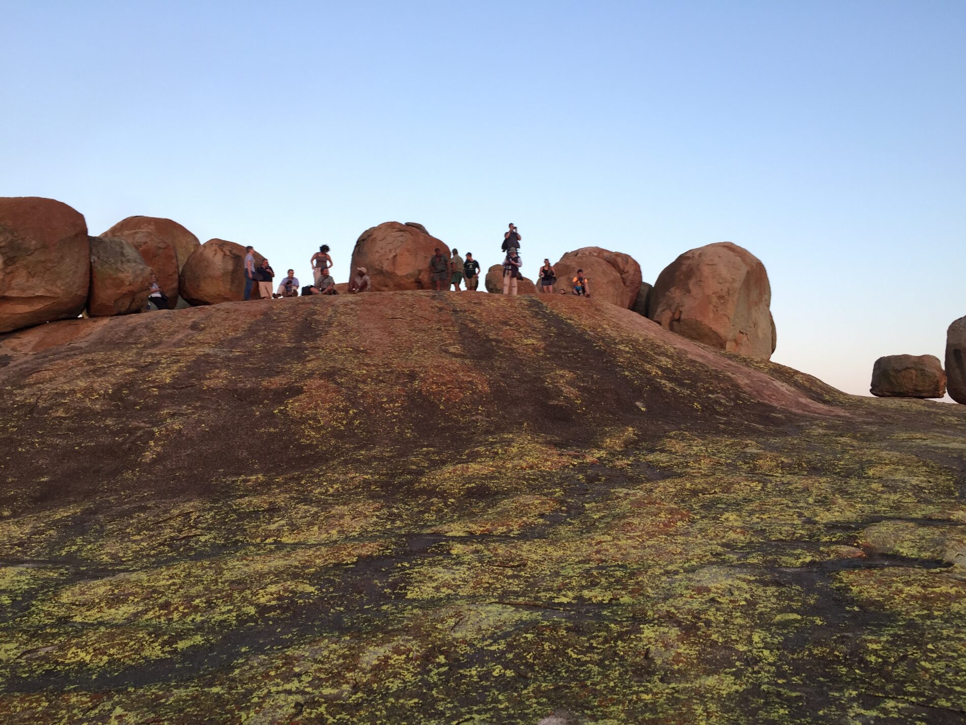 wide angle of people standing by big boulders