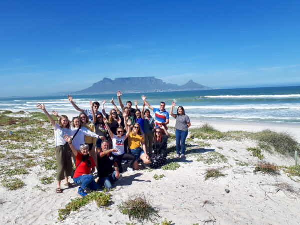 a group of tourists posing in front of table mountain in cape town