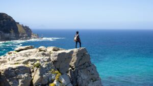 a person standing on a cliff looking out at the ocean