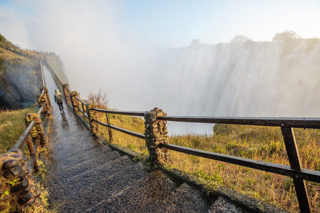 Person walking along boardwalk at Victoria Falls in Zimbabwe.