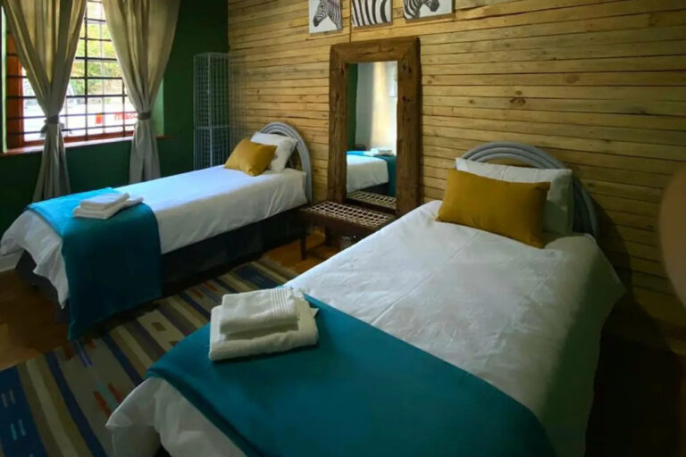 bedroom with two beds and a mirror
