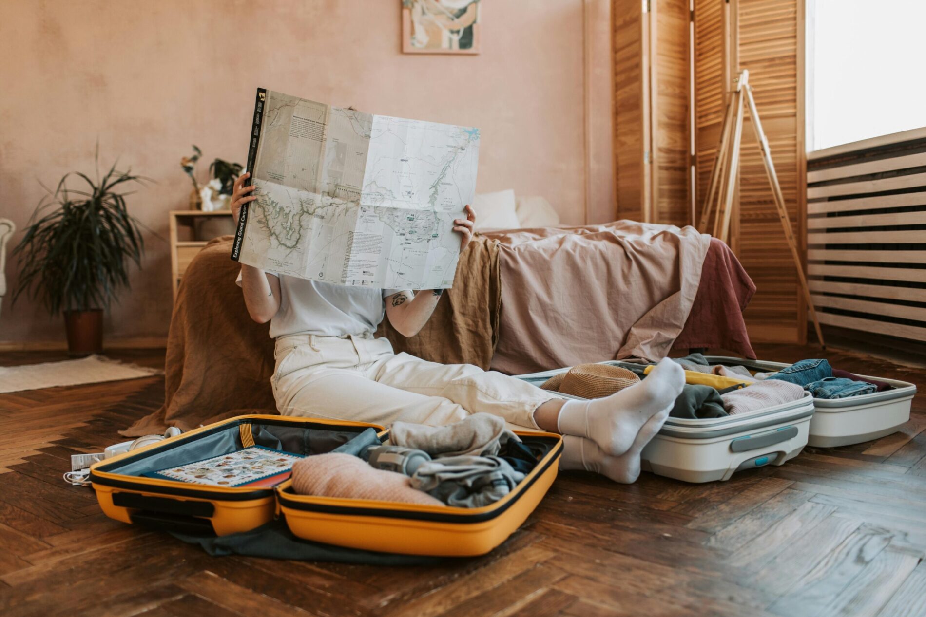 Person packing for their holiday and looking at map