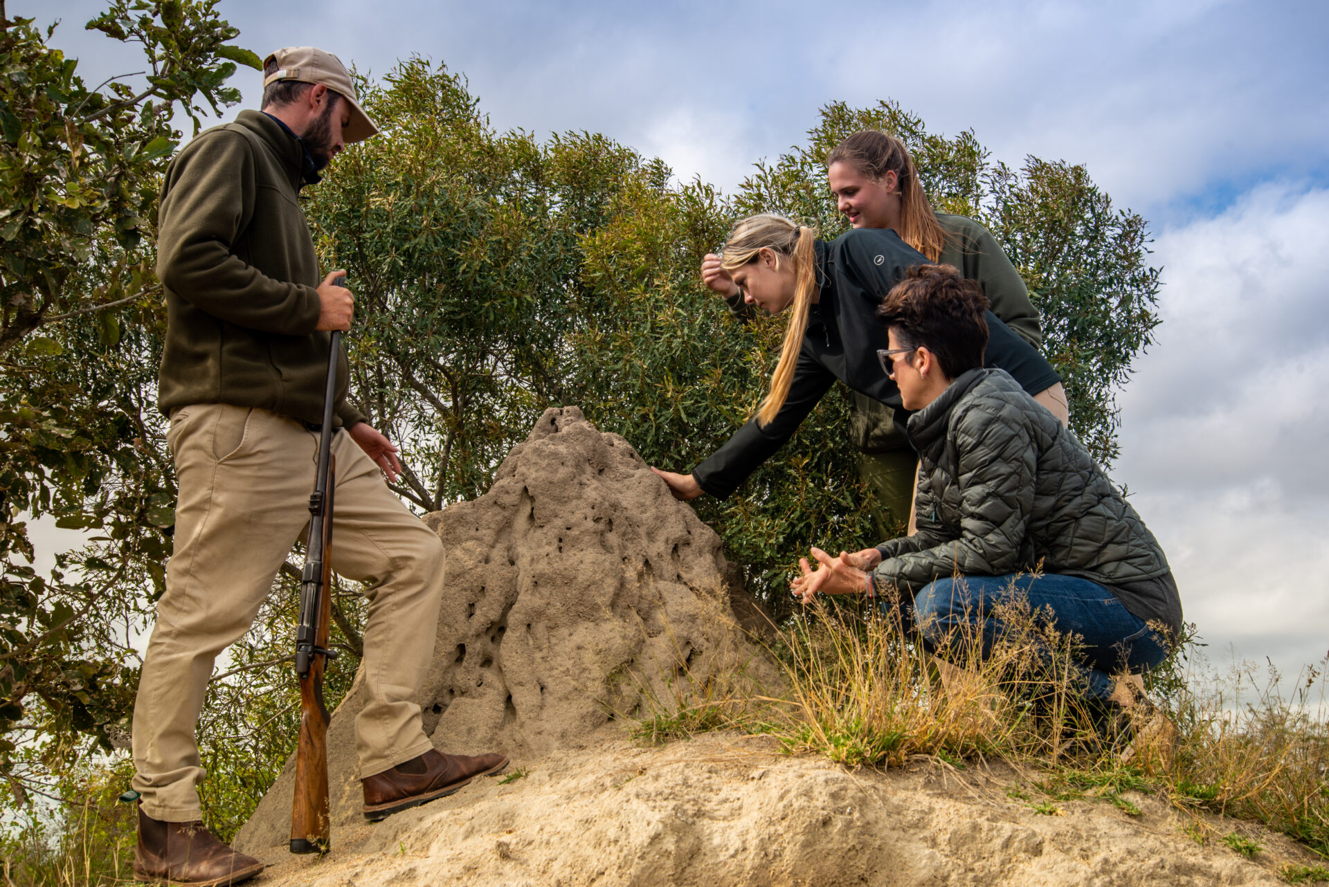 people inspecting a ant hill on a bush walk