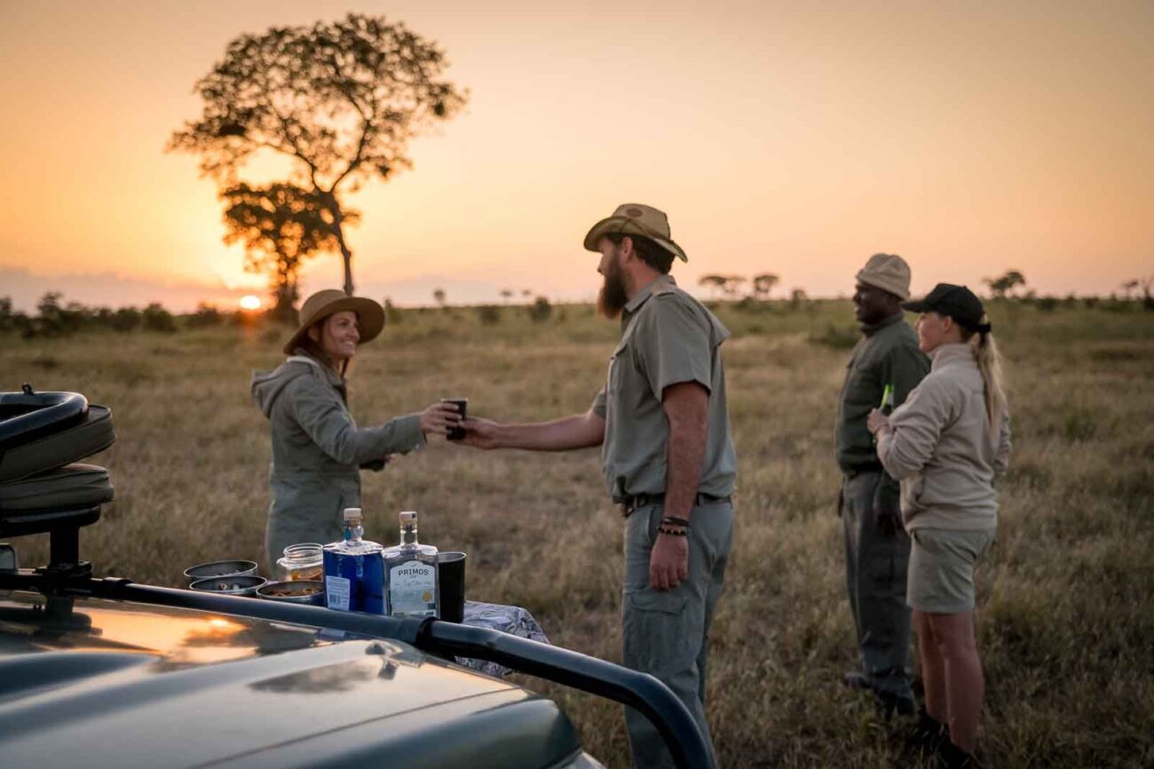 tour guide giving tourist glass while sun is setting in the background