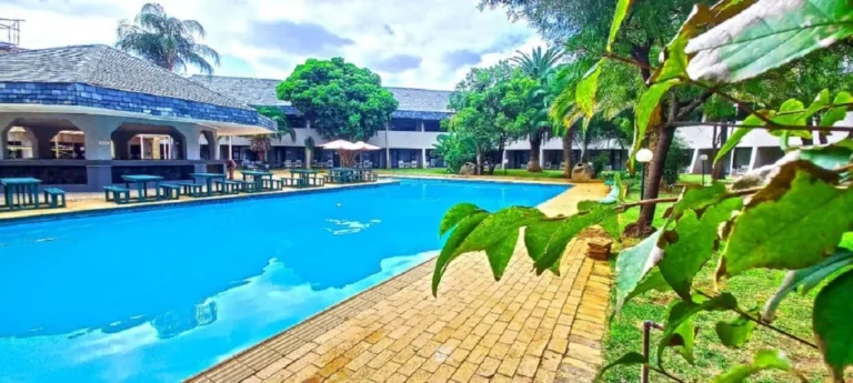 outside of a lodge with benches, trees AND A POOL