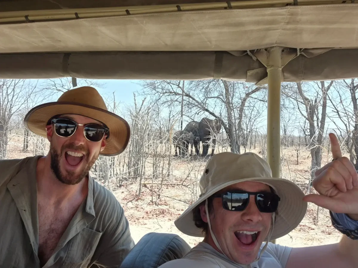 men-posing-on-game-drive-elephant-background