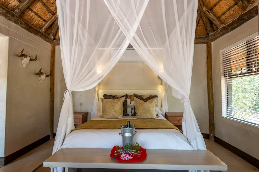 inside of a luxury suite with a bed and a bottle of champagne