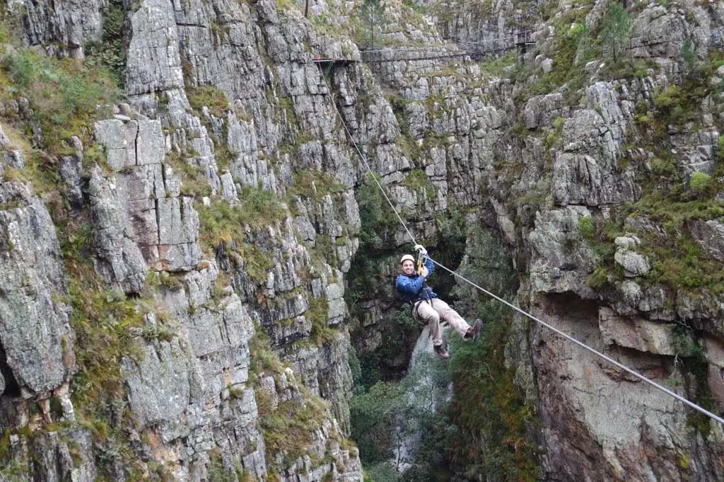 Man smiles as he ziplines on canopy tour